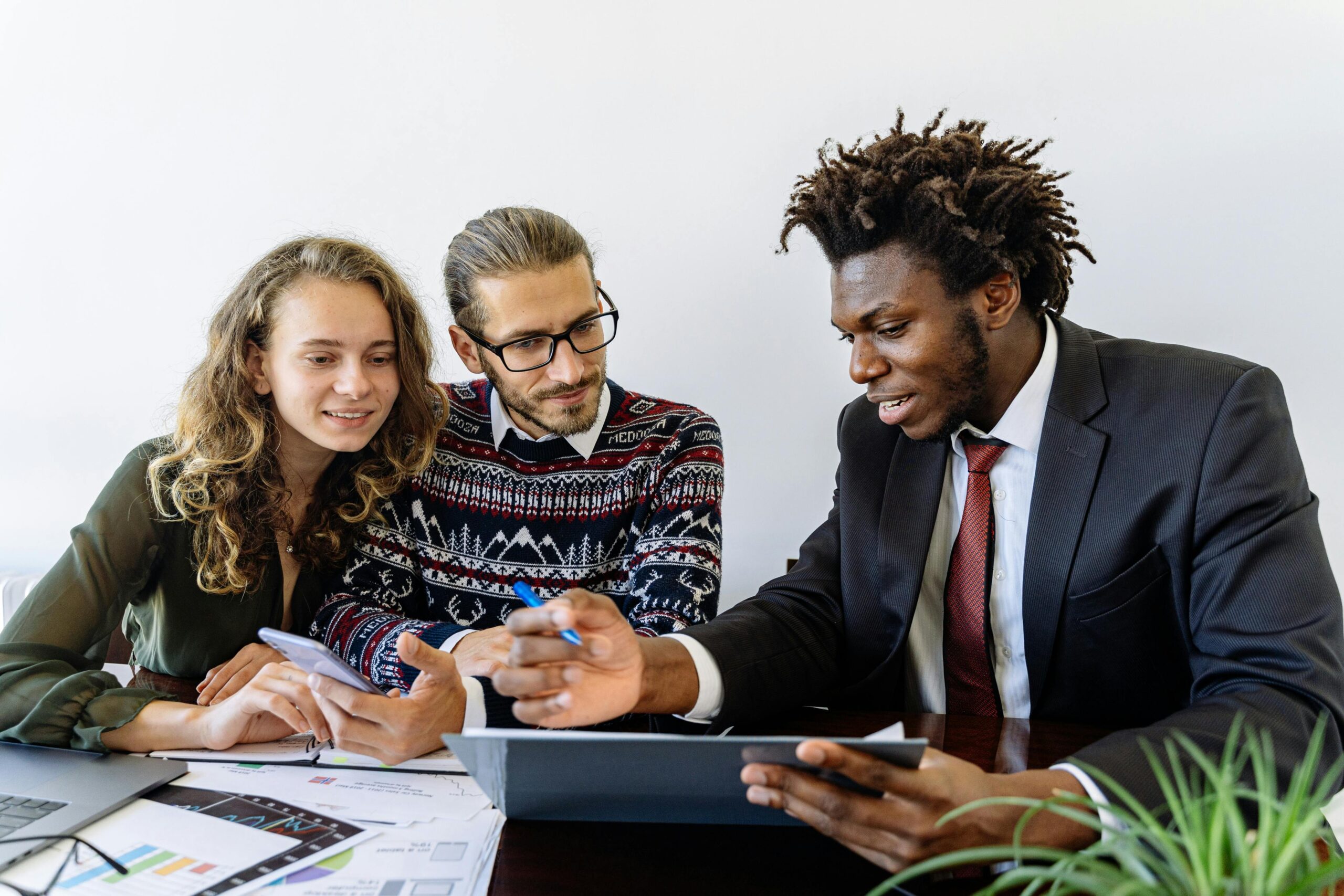 Three professionals engaging in a collaborative business meeting in a modern office environment.