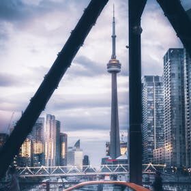 Stunning view of Toronto's skyline featuring the CN Tower and a yellow taxi at dusk.